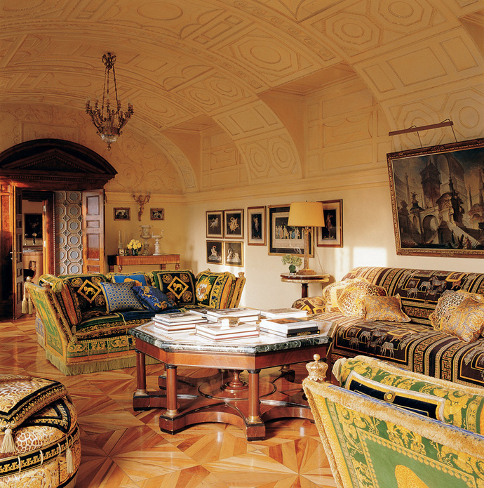 Маленькая гостиная на втором этаже квартиры. Вокруг коктейльного столика со столешницей из искусственного мрамора стоят диваны из коллекции Versace для дома. На стене — картины современного художника Миммо Паладино.