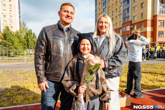 Школьницу привели на линейку мама и папа | Источник: Кирилл Башинский / NGS55.RU