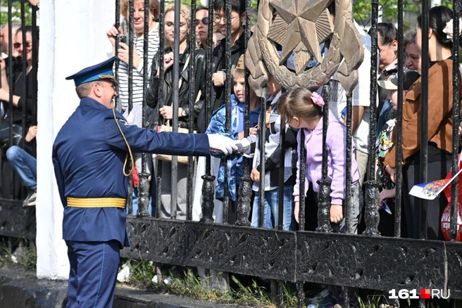 Участник парада пожимает руку мальчику-зрителю | Источник: Евгений Вдовин / 161.RU