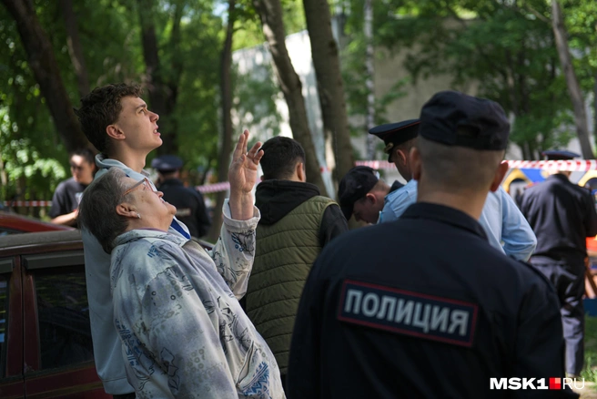 Жители дома собрались за оцеплением и всматриваются в свои окна | Источник: Артем Устюжанин / MSK1.RU