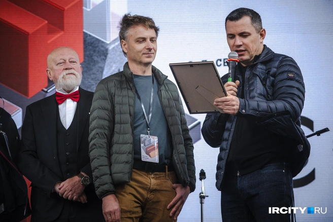 Первый заместитель председателя правительства Приангарья Руслан Ситников (справа) вручает грамоту с благодарностью председателю регионального отделения Союза архитекторов России Руслану Хотулеву (в центре) | Источник: Арсений Чекмарев / «ИрСити»
