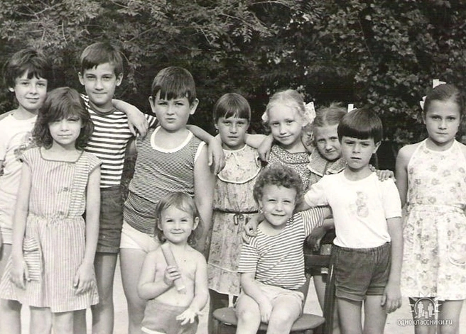 Евгений (третий справа, на стуле) на снимке с детьми из своего двора | Источник: из личного архива Евгения