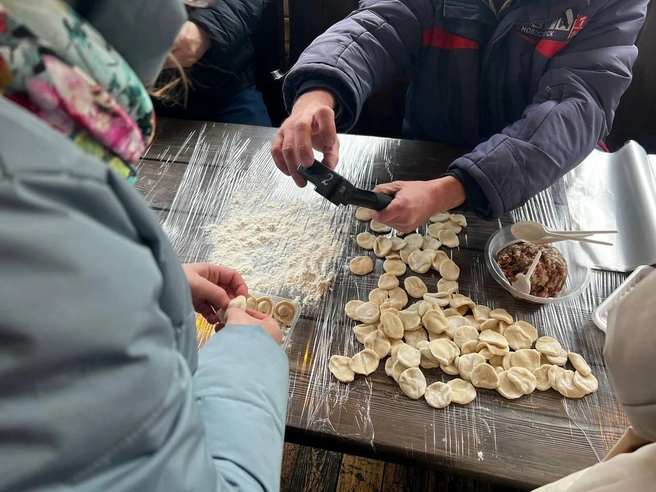 Две команды занимаются лепкой пельменей. | Источник: Анна Скок / NGS.RU