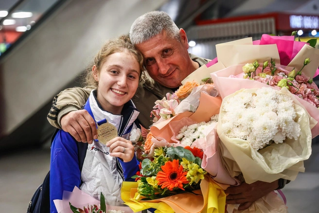 Победительница с папой в аэропорту | Источник: Андрей Голубенко