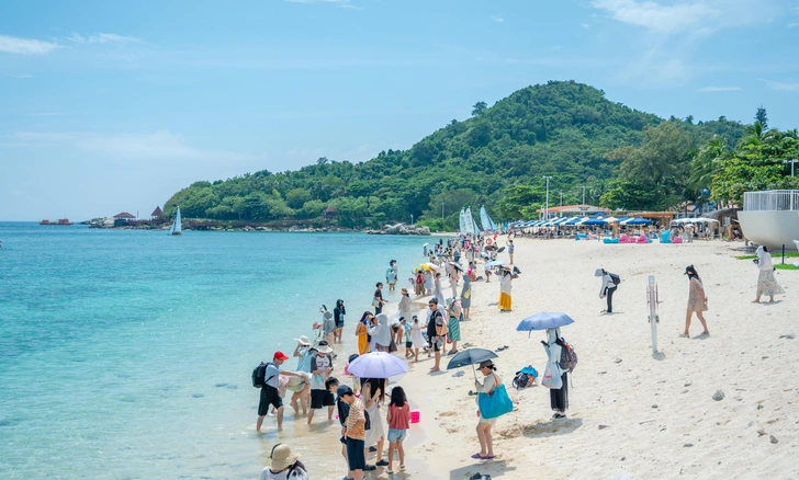 Туристы гуляют по пляжу на китайском курорте Санья | Источник: Imaginechina via Legion Media