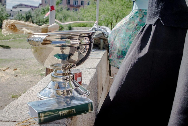 Чаша с освещённой водой стоит на опорной стене, собранной из надгробий со Старочитинского кладбища | Источник: Анна Хвостова