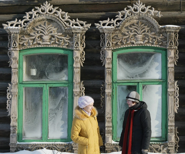 Две девушки разговаривают около деревянного дома | Источник: PhotoXPress.ru