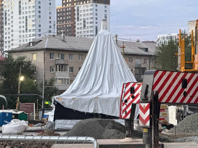 Шпиль, укрытый тентом, ожидает подъема на крышу. | Источник: читательница E1.RU
