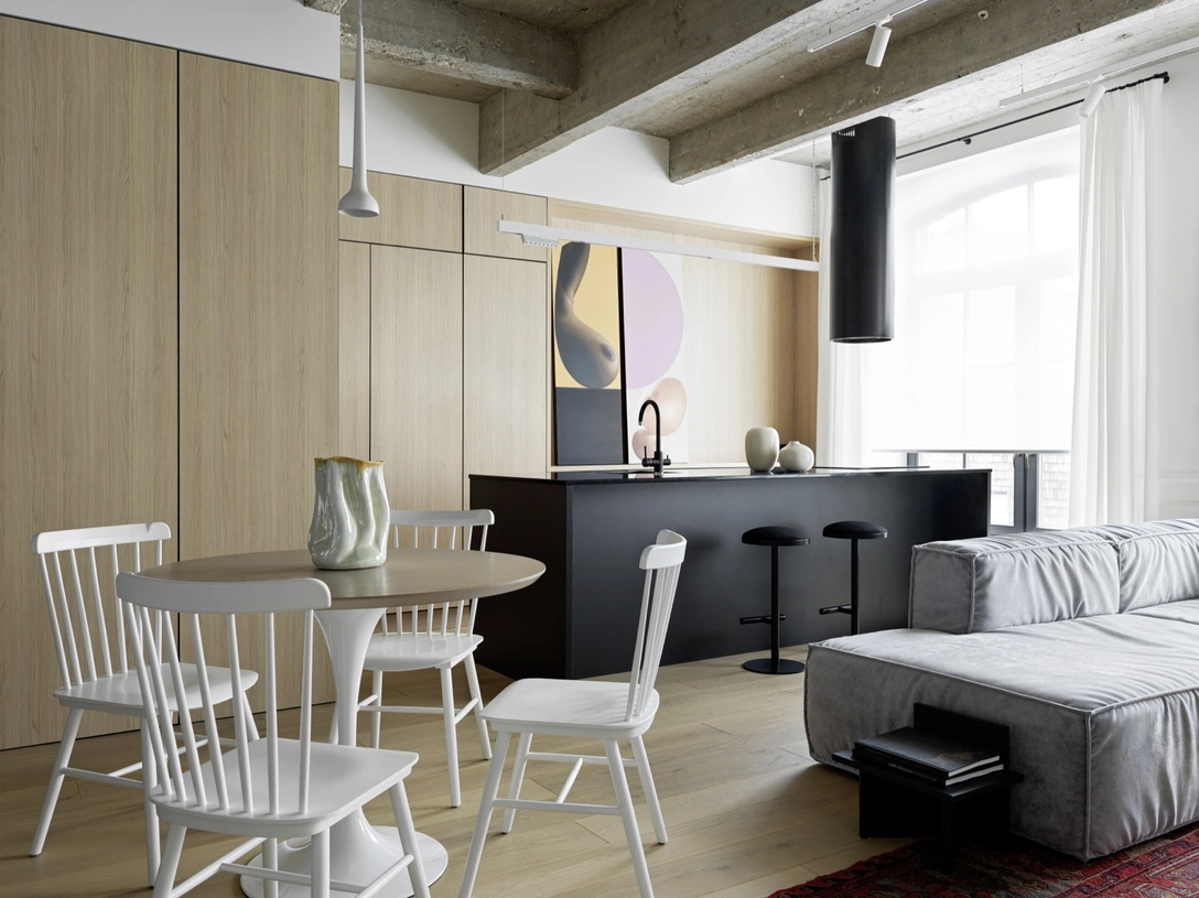 Гостиная и кухня расположены в едином открытом пространстве. Картина Анастасии Ларионовой. Диван, Ossen. Магнитный трек над кухонным островом, компания «Стильный свет». Вытяжка, Maunfeld. Барные стулья, Am.Pm. Вазы, Zara Home. | mcmaison.ru