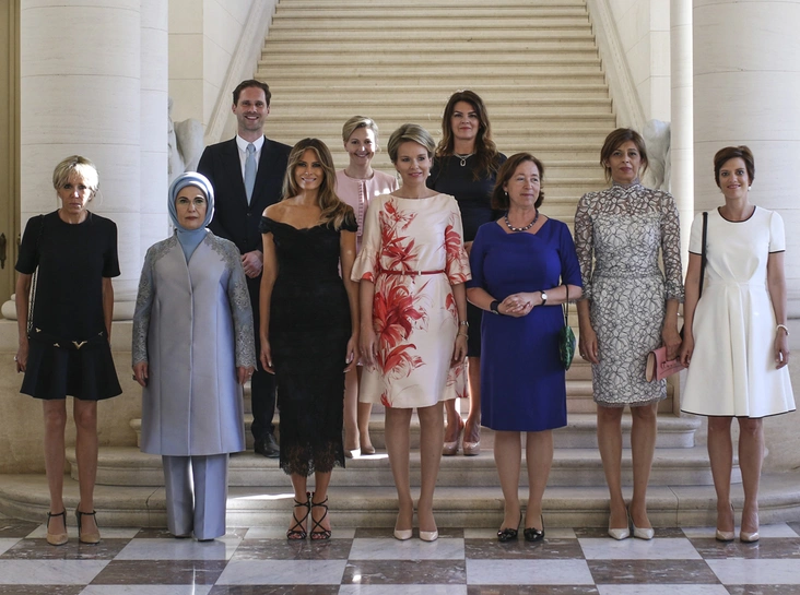 В первом ряду, слева направо:
первая леди Франции Брижит Макрон, первая леди Турции Эмине Гюльбаран Эрдоган, первая леди США Мелания Трамп, королева Бельгии Матильда, спутница генерального секретаря НАТО Йенса Столтенберга Ингрид Шулеруд, Первая леди Болгарии Десислава Радева, подруга бельгийского премьера Шарля Мишеля - Амели Дербаудренгьен.
Слева направо во втором ряду:
супруг премьер-министра Люксембурга Ксавье Беттеля – Готье Дестне, гражданская жена премьера Словении Мирослава Церара-младшего – Мойка Стропник, Первая леди Исландии Маргрет Балдвинсдоттир.