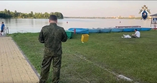 Парень в белой футболке слева — по словам очевидцев, брат погибшего мальчика. Он долго сидел возле накрытого тела. | Источник: Западное межрегиональное следственное управление на транспорте СКР, стоп-кадр с видео / zmsut.sledcom.ru