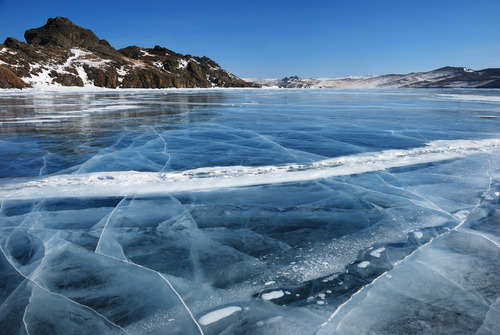 shutterstockПроисходит это потому, что при температуре +4°С пресная вода приобретает свою наибольшую плотность. При дальнейшем охлаждении она становится гораздо менее плотной и более легкой. Поэтому как только осенью вся толща воды в озере остужается до +4°, верхний ее слой, продолжающий охлаждаться, становится легче, чем вода нижних слоев. Холодная и легкая «верхняя» вода плавает над более теплой, а следовательно, тяжелой глубинной. Перемешивание слоев происходит очень медленно, поэтому верхний слой воды, а затем и лед не дают озеру промерзнуть, и зимой температура в глубине озера держится в пределах от 1 до 4 градусов тепла. До дна же промерзают лишь мелкие озера, да и то в очень сильный мороз.