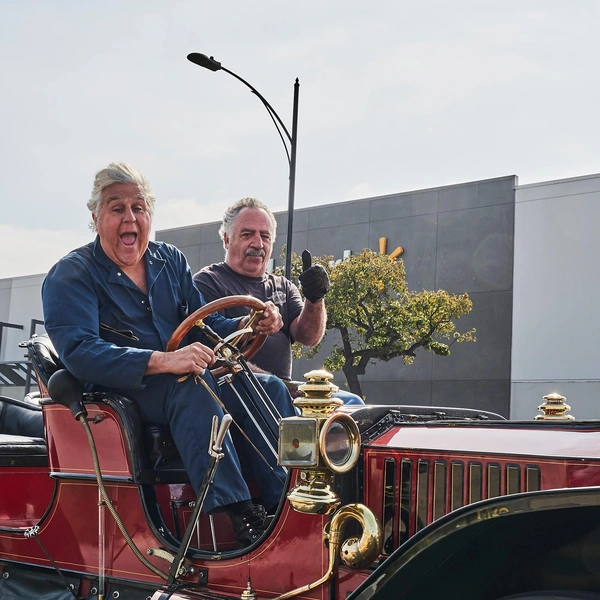 Джей Лено и пассажир едут на автомобиле Stanley Steamer 1909 года | Источник: Evan El-Amin/Shutterstock/Fotodom.ru
