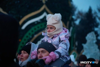 Но не все хотели познакомиться с Дедом Морозом лично. Кому-то достаточно было посмотреть издалека, тем более на плечах у папы так удобно | Источник: Даниил Конин / «ИрСити»