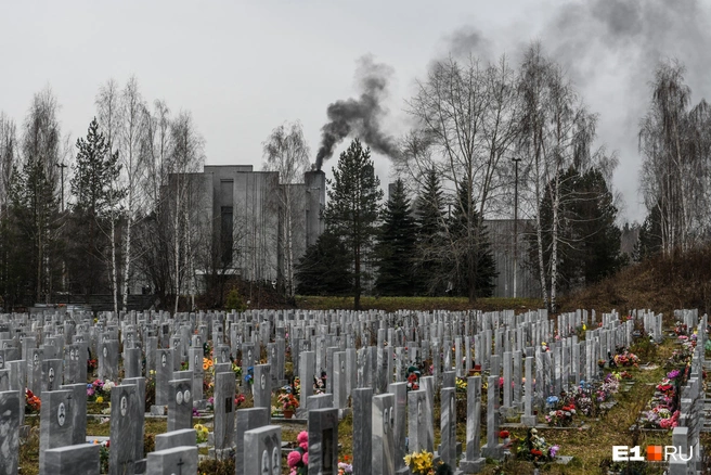 Сибирское кладбище в Екатеринбурге имеет открытый колумбарий, где доступны ниши для захоронения урн с прахом, на заднем плане дымит крематорий | Источник: Артем Устюжанин / E1.RU
