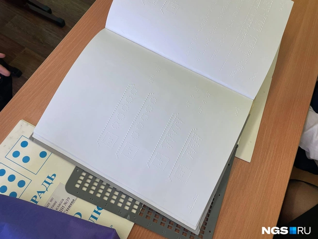 Пишут дети в специальных тетрадях, с использованием вот такой решетки&nbsp;— она имитирует клетки. Такой же прибор есть и в линейном формате | Источник: Алёна Золотухина / NGS.RU 