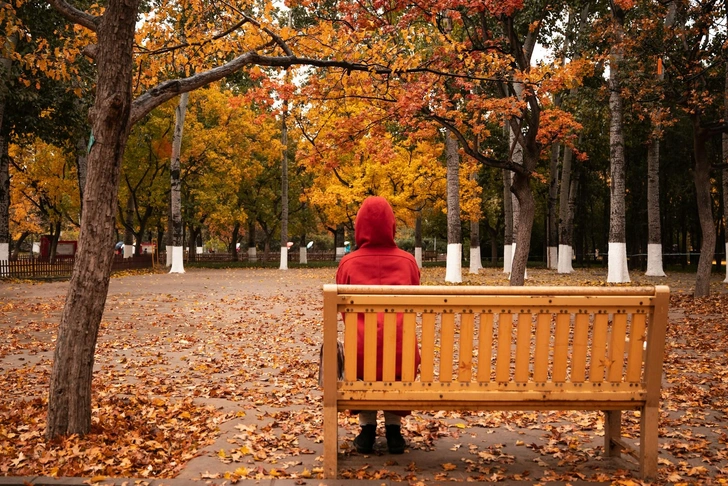 Женщина сидит на скамейке в осеннем парке | Источник: seven T / Unsplash