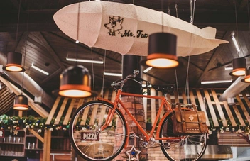 Под полотком висит велосипед, который уже стал визитной карточкой заведения | Источник: Mister Fox