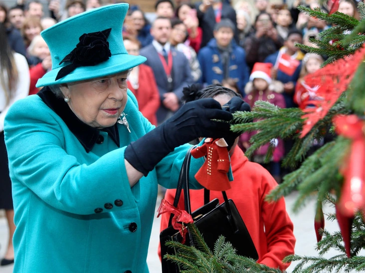 Елизавета II подвешивает елочную игрушку на открытии Queen Elizabeth II Centre, Лондон, 5 декабря 2018