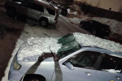 Снег обрушился на припаркованную машину в Новосибирске