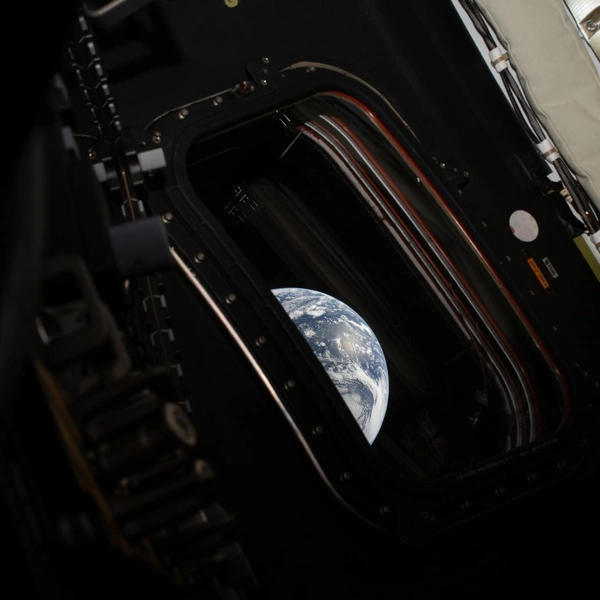 Вид на Землю, снятый астронавтом НАСА и командиром миссии Artemis II Ридом Уайзманом из одного из четырех основных окон космического корабля Orion после завершения маневра по выходу на транслунную траекторию 2 апреля 2026 года. | Источник: NASA