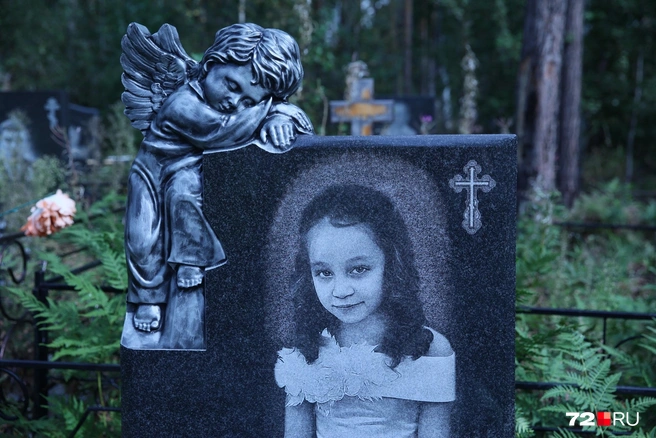 На могиле год назад появился памятник. С него смотрит пронзительным взглядом маленькая и такая беззащитная Настя  | Источник: Ирина Шарова / 72.RU