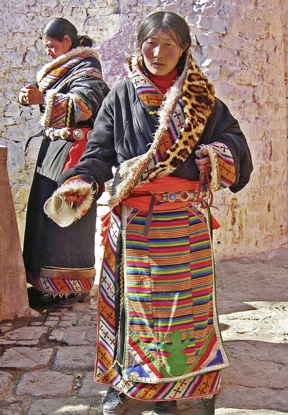 Молодая женщина собирает пожертвования в монастыре Ташилхумпо | Источник: bernotto / Contributor / iStock