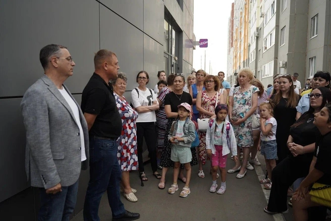 Максим Амелин (слева в сером) и Денис Батурин (правее от него в черном) разговаривают с жителями 16 микрорайона | Источник: Максим Амелин / Вконтакте