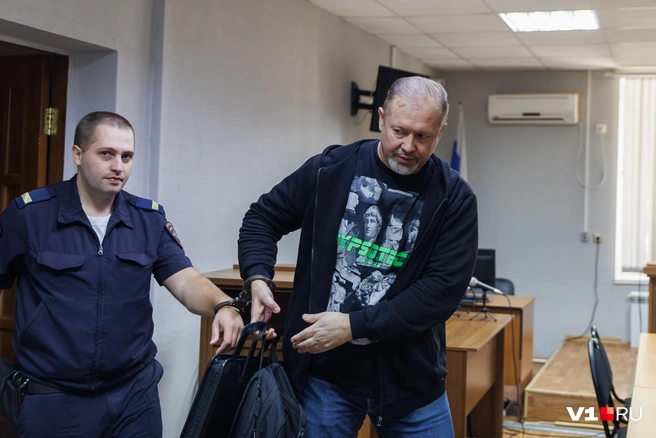 Папку с многочисленными документами неудобно нести в прикованной к конвоиру руке | Источник: Алексей Волхонский / V1.RU