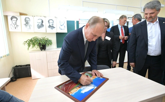Владимир Путин оставил свою подпись на фотографии школы во время посещения | Источник: Кremlin.ru