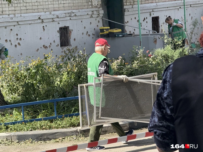 Коммунальщики собирают вынесенные взрывом оконные сетки | Источник: Сергей Петунин / 164.RU