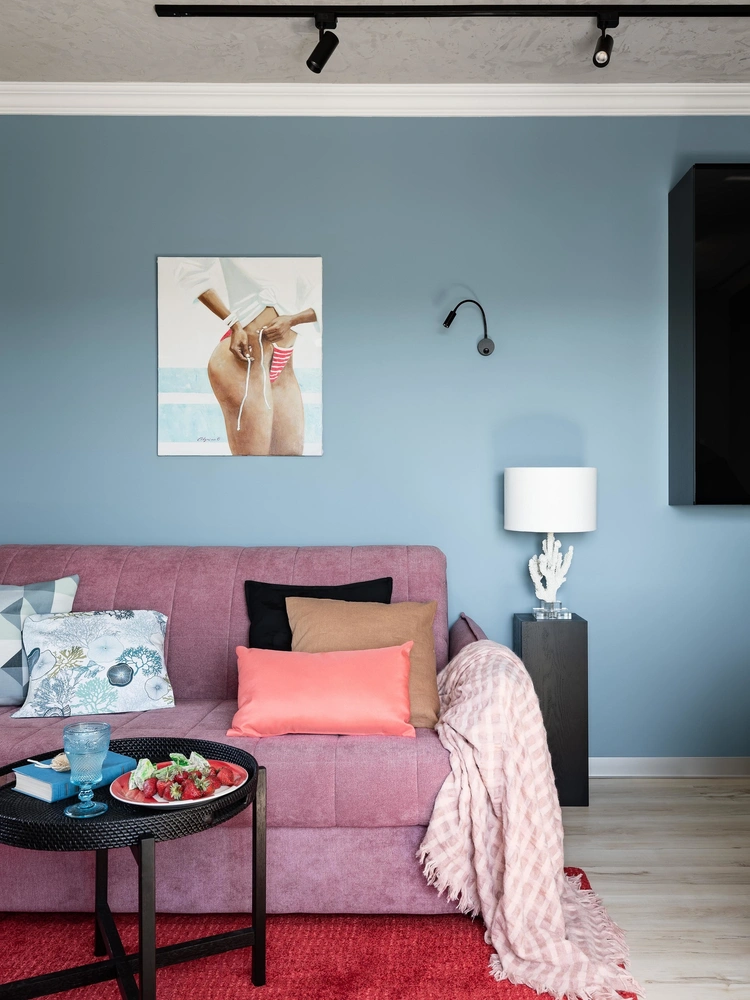 Гостиная. Декоративные подушки и ковер, ИКЕА. Журнальный столик, H&М Home. Плед и настольная лампа, Zara Home. На стене — картина Олеси Алыниной «Девушка в купальнике». | mcmaison.ru