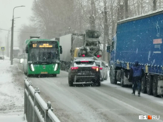 Автобус ждет, когда ему освободят путь. Вот только деваться водителям некуда&nbsp;— справа от них припаркованы грузовики | Источник: Роман Марьяненко / E1.RU