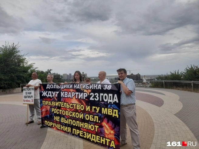 С правой стороны плакат держат дольщики Андрей Дробязко и Эдуард Попов | Источник: Ксения Сухоленко / 161.RU