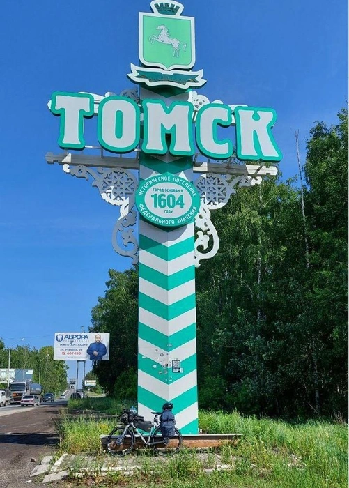 Велосипед Мустафы на фоне стелы на въезде в Томск | Источник: «и Мужчина, и Машина» / T.me