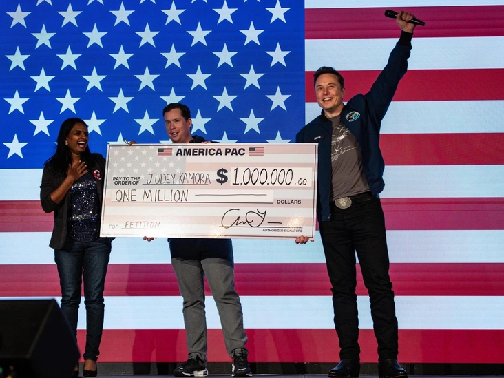 Илон Маск вручает Джуди Камора чек на $1 миллион во время городского собрания America PAC в Ланкастере, штат Пенсильвания, 26 октября 2024 года