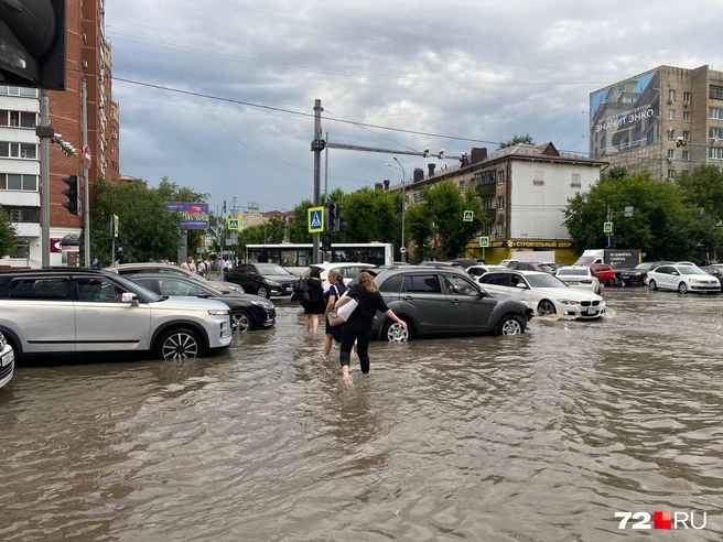 Горожане были вынуждены переходить дорогу таким вот способом. Одни снимали обувь, вторые — надевали пакеты на ноги или мусорные мешки | Источник: 72.RU