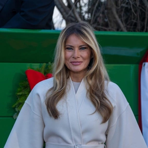 Мелания Трамп снова в белом пальто — теперь принимает рождественскую ель