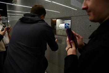 Люди фотографируют миниатюру щита, который строил метро | Источник: Дарья Шутова / MSK1.RU