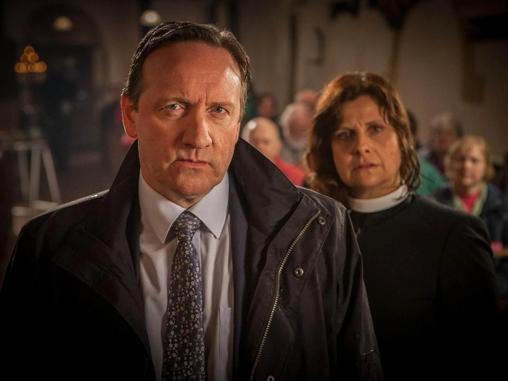 Королева Елизавета II была поклонницей сериала и лично вручила Джону Неттлзу Орден Британской Империи за заслуги в области драматического искусства. | Источник: Кадр из сериала «Чисто английские убийства»