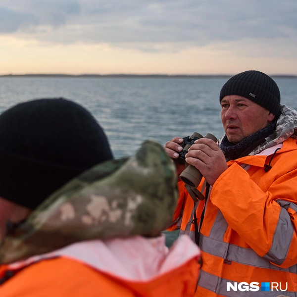 Кирилл и Николай Степанович на палубе высматривают сигналы, которые подают им с катера | Источник: Александр Ощепков / NGS.ru