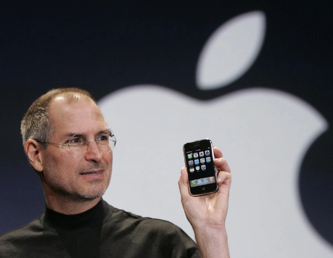Стив Джобс с первой моделью Apple iPhone на конференции MacWorld в Сан-Франциско в 2007 году | Источник: Paul Sakuma / AP / ТАСС
