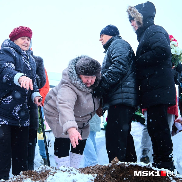 По узкой тропинке собравшиеся на кладбище подходили к могиле, чтобы бросить горсть земли | Источник: Дмитрий Толстошеев / MSK1.RU