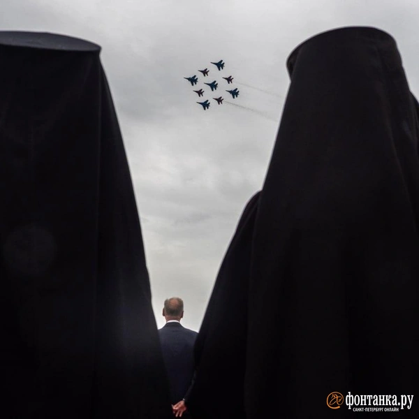 Священники смотрят выступление пилотажной группы «Стрижи» на открытии международного военно-морского салона. | Источник: Михаил Огнев / FONTANKA.RU