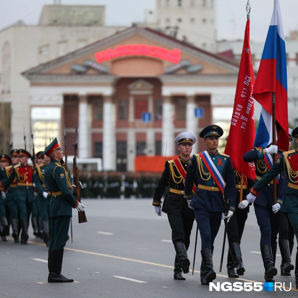 Рядом с российским триколором — знамя Победы. Флаги несут с гордостью | Источник: Евгений Софийчук / NGS55.RU