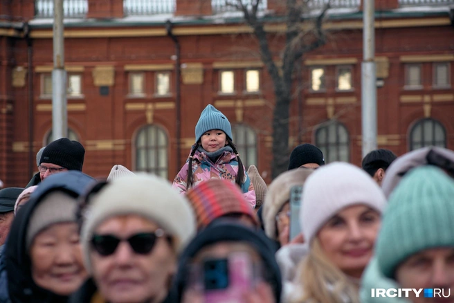 Кто-то устроился на родительских плечах, живо интересуясь происходящим у мам и пап | Источник: Даниил Конин / «ИрСити»
