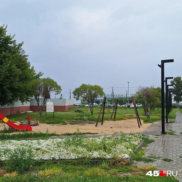 За детской площадкой виднеется здание курганского аэропорта | Источник: Александр Лисихин /45.ru