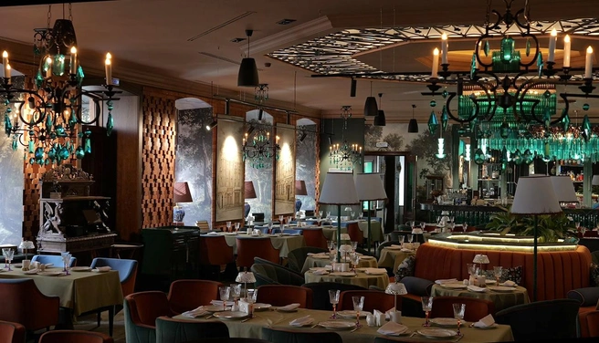 Интерьер заведения выполнен в темных тонах, акценты сделаны на малахитовом и кирпичном цветах | Источник: родная-кухня.рф