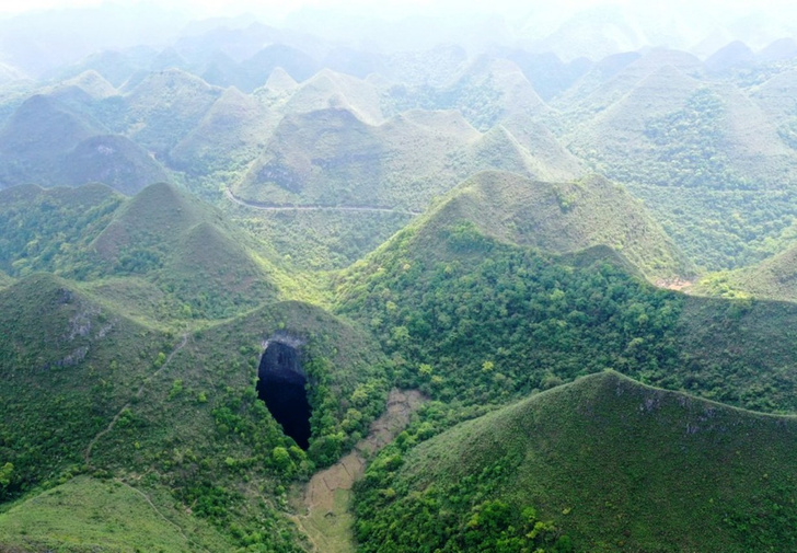 Небесная яма: китайские спелеологи открыли 192-метровую воронку с древним лесом