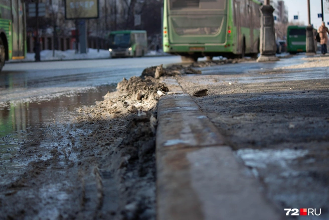 Посмотрим на эту грязь поближе. В карманах остановок снег не убран&nbsp;— вот и поплыло | Источник: Павел Красоткин / 72.RU